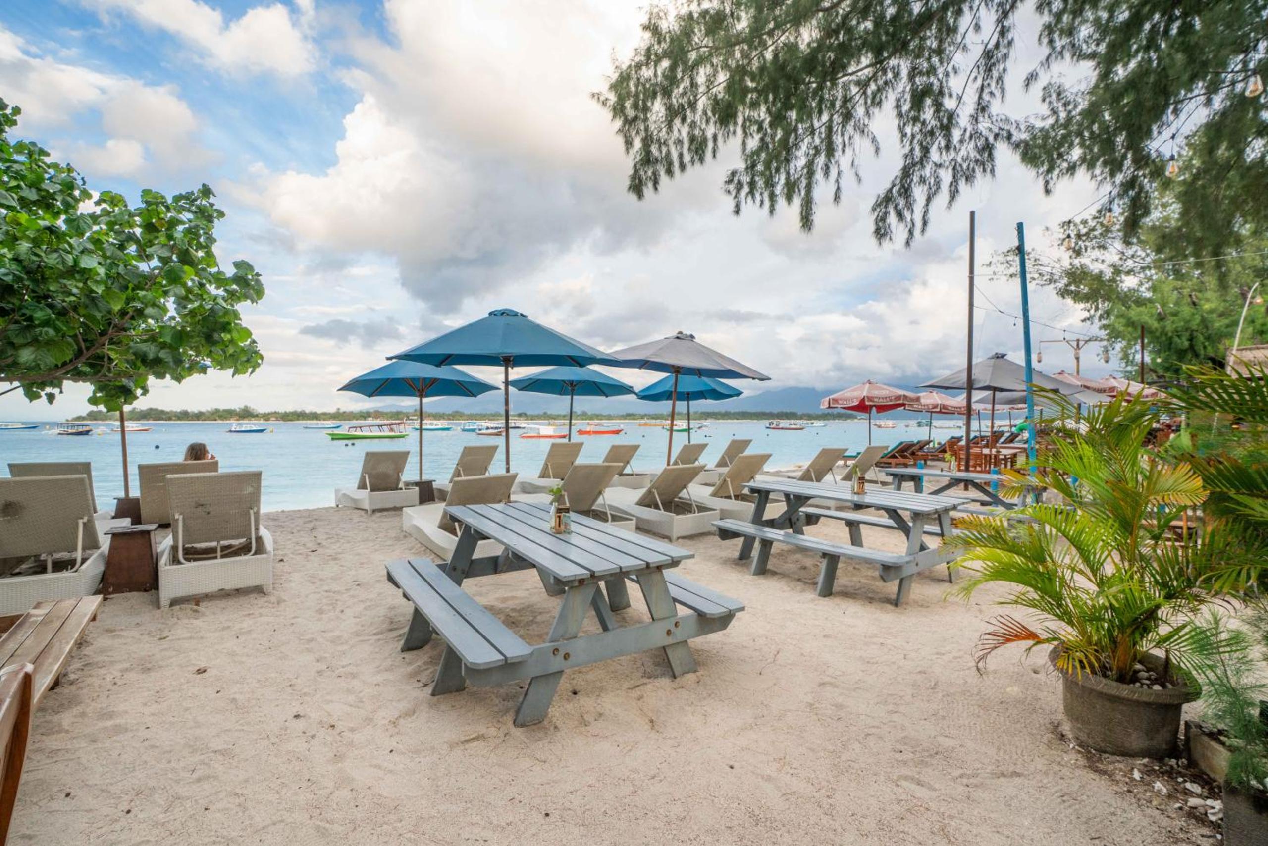 Beachfront seating and umbrellas at Balé Sampan