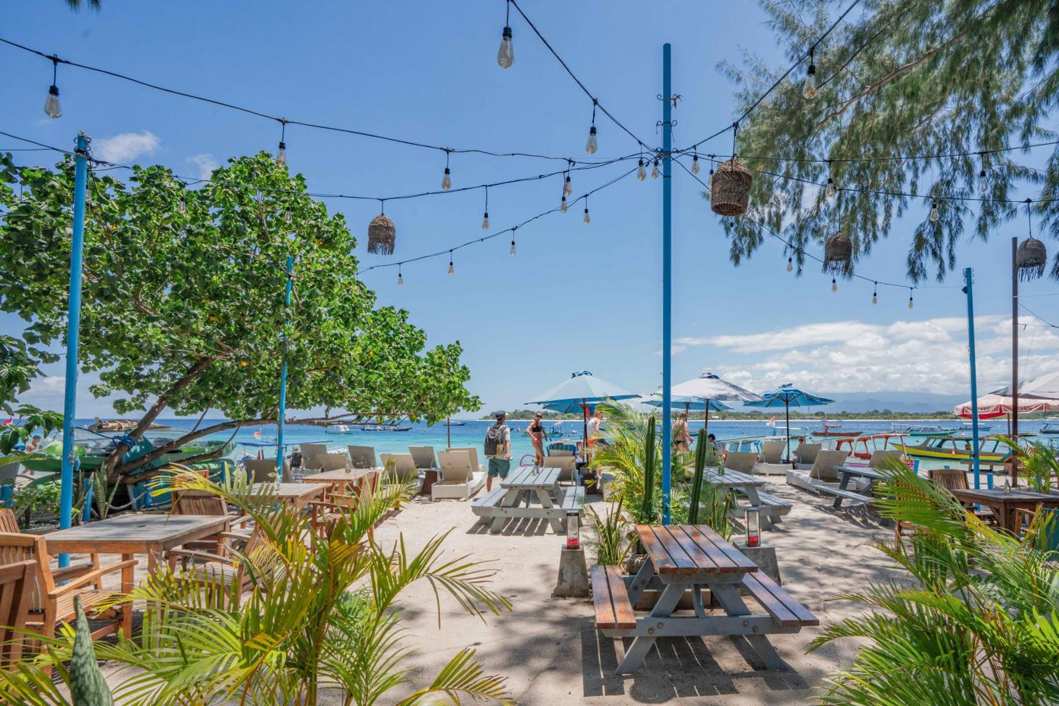 Beachfront seating and umbrellas at Balé Sampan